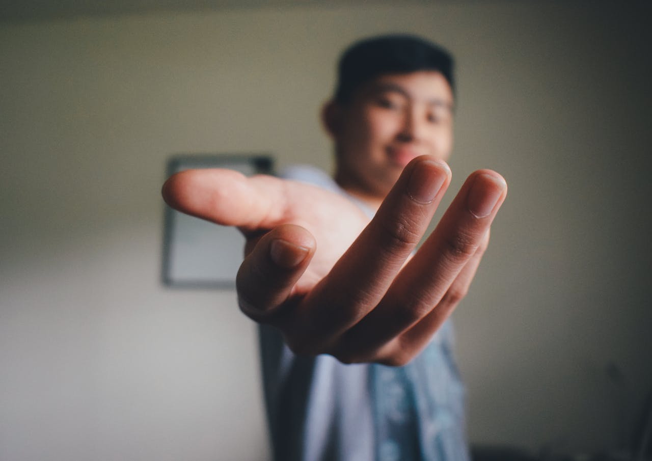 about-01 A man reaching out with an open hand, symbolizing connection and approachability.