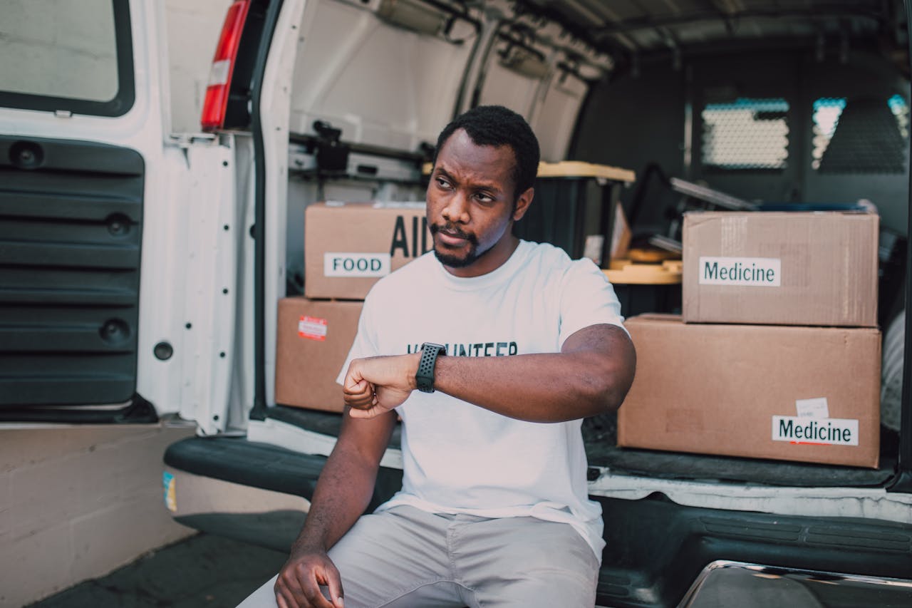 ours-journey A volunteer organizing aid deliveries including food and medicine from a van.