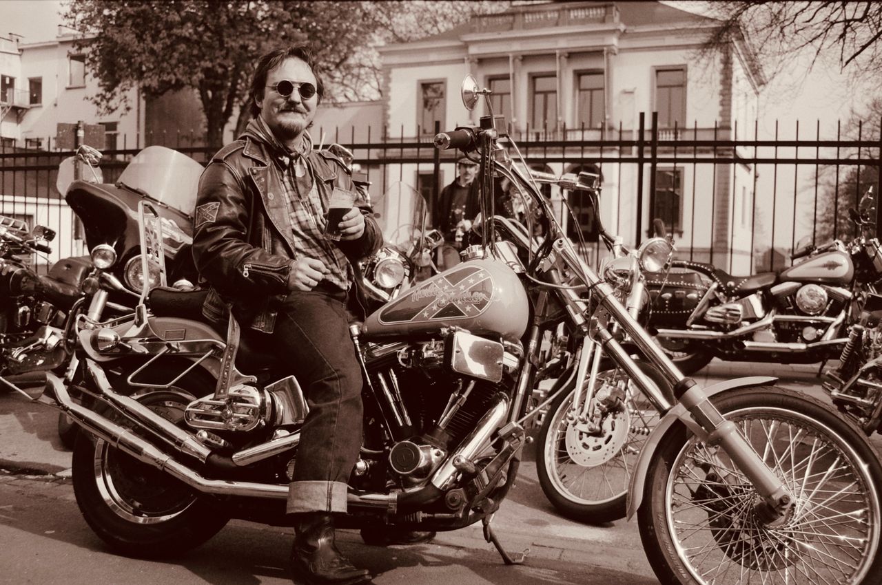 Man on a motorcycle enjoying urban landscape. Vintage style photograph.