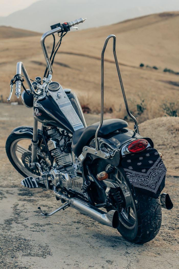 journey-02 A black motorcycle parked on a dirt road in Urmia, Iran, showcasing vintage design.